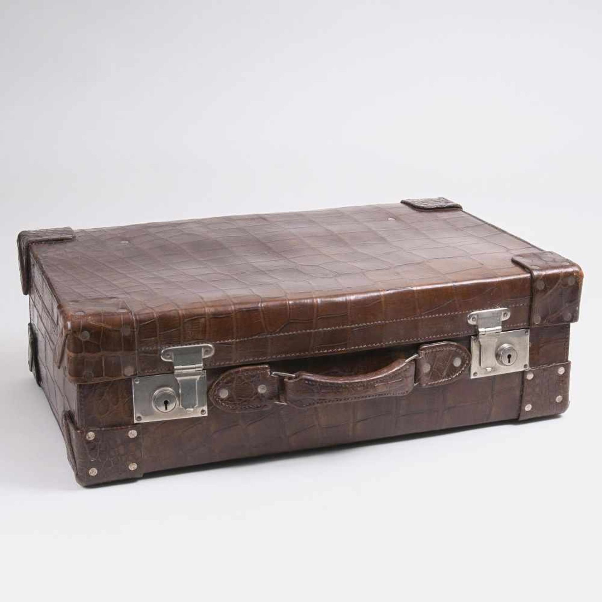 Kroko-ReisekofferUm 1930. Krokodilleder, braun. Geräumiger Koffer mit Tragegriff und zwei