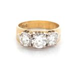 A DIAMOND TRILOGY RING centred by a claw-set round brilliant-cut diamond, weighing approximately 0,
