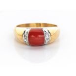 A CORAL AND DIAMOND RING NOT SUITABLE FOR EXPORT centred by a coral flanked by 2 pavé-set round