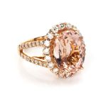 A DIAMOND AND MORGANITE RING centred by an oval claw-set mixed-cut morganite, weighing approximately