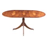 A REGENCY STYLE WALNUT AND MAHOGANY EXTENDING DINING TABLE the oval crossbanded top above a reeded