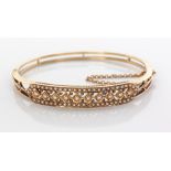 A VICTORIAN SEED PEARL BANGLE hinged, centred by 10 diamond shapes each centred by a claw-set seed