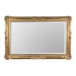 A GILDED MIRROR the rectangular bevelled plate within an ornate moulded gold frame 123cm high, 171,