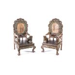 A PAIR OF CARVED WOODEN ARMCHAIRS each arched back surmounted by pierced carving, curved arms on