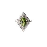 A PERIDOT AND DIAMOND RING claw-set to the centre with a oval-shaped natural peridot, weighing 3,