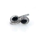 A PAIR OF SAPPHIRE AND DIAMOND EARRINGS claw-set to the centre with two matching oval sapphires with