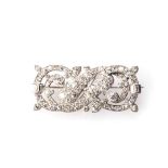 A PLATINUM BROOCH pavé-set as an intricate swirl with sixty round brilliant-cut, and six baguette-