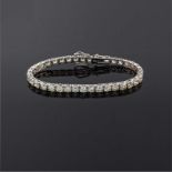 A DIAMOND TENNIS BRACELET Claw set with thirty-eight round brilliant cut diamonds weighing