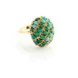 A TURQUOISE AND 18CT GOLD RING Centred with a domed oval plaque embellished with gently undulating