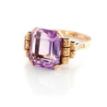 AN AMETHYST RING Claw set to the centre with an emerald-cut amethyst weighing approximately 5.