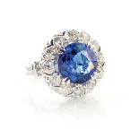 A SAPPHIRE AND DIAMOND RING Designed as a stylised flower, claw set to the centre with an oval cut