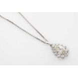 A DIAMOND PENDANT Centred by a claw set pear shaped diamond surrounded by twelve claw set round