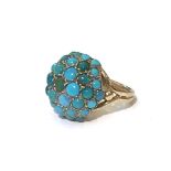 A TURQUOISE AND 9CT GOLD RING Centred with a circular dome pave set with round turquoise