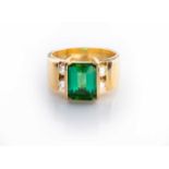 A TOURMALINE AND DIAMOND RING tension-set to the centre with an emerald-cut tourmaline weighing