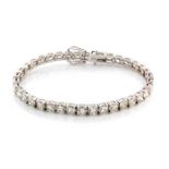 A DIAMOND TENNIS BRACELET Claw set with thirty-seven round brilliant cut diamond weighing