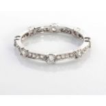 A DIAMOND ETERNITY RING Claw set with round brilliant cut diamonds alternating with four