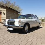 A 1970 MERCEDES-BENZ 230.6 Floor shift automatic sedan finished in papyrus white with original red