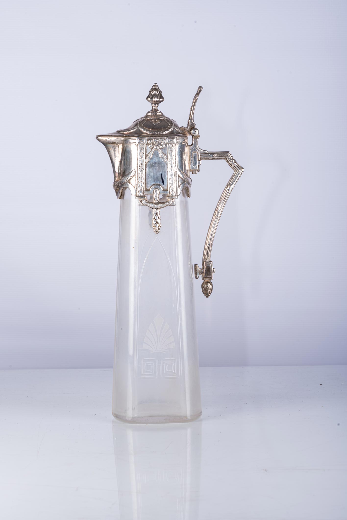 A SILVER CLARET JUG The tapering body with faceted motif, surmounted by a silver collar with