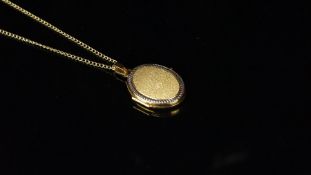Oval locket hallmarked 9ct gold, on a fine curb chain stamped 9ct to the clasp, chain length