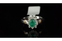 Emerald and diamond cluster ring, oval emerald set in the centre, surrounded by round brilliant cut