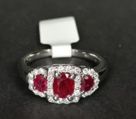 Ruby and diamond ring, central oval cut ruby, surrounded by round brilliant cut diamonds with a semi