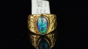 An opal triplet dress ring, with a rub over set pear cabochon opal triplet, measuring