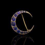 Crescent brooch set with blue stones, mounted in hallmarked 9ct yellow gold, set with thirteen