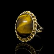 Tiger's Eye dress ring mounted in yellow metal stamped 9ct, oval cabochon Tiger's Eye stone with