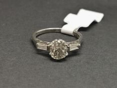 Three stone old cut diamond and baguette cut diamond ring, mounted in white metal stamped '18ct &