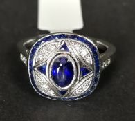 Sapphire and diamond ring, central oval cut sapphire, with a triangular cut sapphire set to each