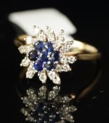 A sapphire and diamond ring, central seven stone sapphire cluster, surrounded by a spray of single