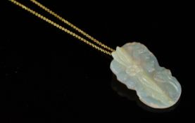 Carved opal pendant with yellow metal pendant loop, hung on a yellow metal chain stamped 750, opal