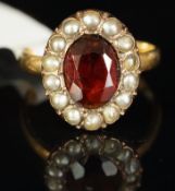 Garnet and split pearl oval cluster ring, mounted in yellow metal, shank stamped 18ct, central