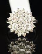 A diamond cluster ring, central seven stone diamond daisy cluster, with a further surround of