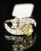 Two stone diamond crossover ring, two cushion cut diamonds, one tinted yellow, in crossover