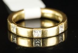 Three stone diamond wedding band, mounted in hallmarked 18ct yellow gold, set with three princess