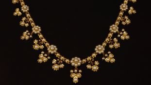 A yellow metal collar necklace, set with seed pearls, designed as daisy clusters, with floral drops,