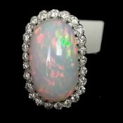 An opal and diamond ring, an oblong shaped cabochon cut opal measuring approximately 17.10 x 10.5mm,