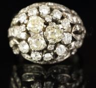 A diamond bombé ring, set with three old cut diamonds to the centre, surrounded by round brilliant