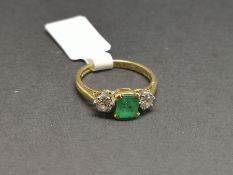 Three stone emerald and diamond ring, central square step cut emerald measuring approximately 5.52 x