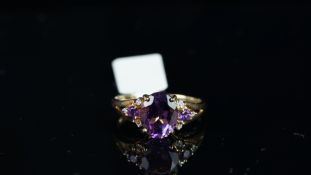 Amethyst and diamond ring, mounted in unmarked yellow metal, central oval amethyst with one round