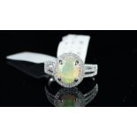An opal and diamond ring, oval faceted opal, weighing an estimated 1.33ct, claw set with a double