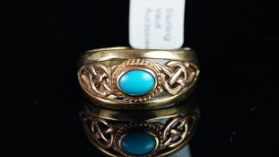 A turquoise band ring, set with an oval cut turquoise at the centre, within a Celtic knot,