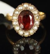 Garnet and split pearl oval cluster ring, mounted in yellow metal, shank stamped 18ct, central