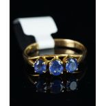 Three stone sapphire ring, set in unhallmarked yellow metal, stamped MG, finger size Q.
