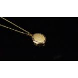 Oval locket hallmarked 9ct gold, on a fine curb chain stamped 9ct to the clasp, chain length