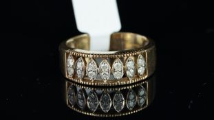 A diamond set half hoop ring, designed as seven navette shaped panels, each set with two round