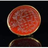 A carnelian seal fob, with a gold handle (damaged), oval carved carnelian seal of a coat of arms,