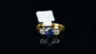 Sapphire and diamond three stone ring, 5.9mm round cut blue sapphire set with a single diamond to