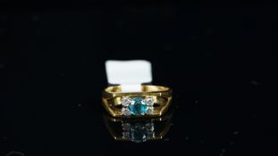 A blue topaz and diamond ring, central blue topaz weighing an estimated 0.36ct, with two round